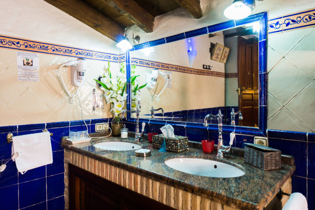 Lavabo de la habitación Orquídea Jacuzzi con doble lavabo, espectacular grifería rústica, espejo, secador de pelo y resto de enseres típicos