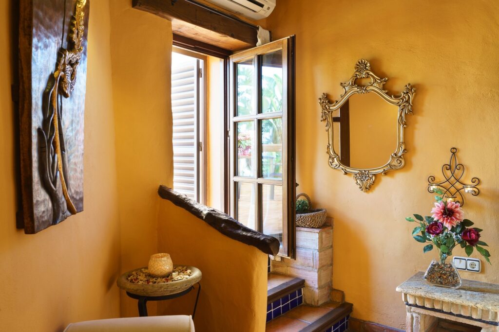 Escaleras de acceso a la terraza privada de la habitación Orquídea Jacuzzi, con espejo y detalles de su espectacular decoración rústica