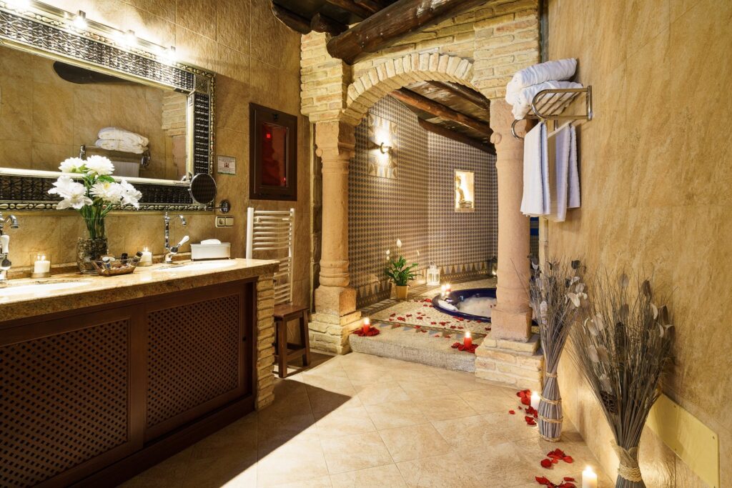 Baño de la habitación Jazmín SPA Exclusive con entrada al Jacuzzi romántico con velas, espuma y pétalos de rosa, dentro de la habitación